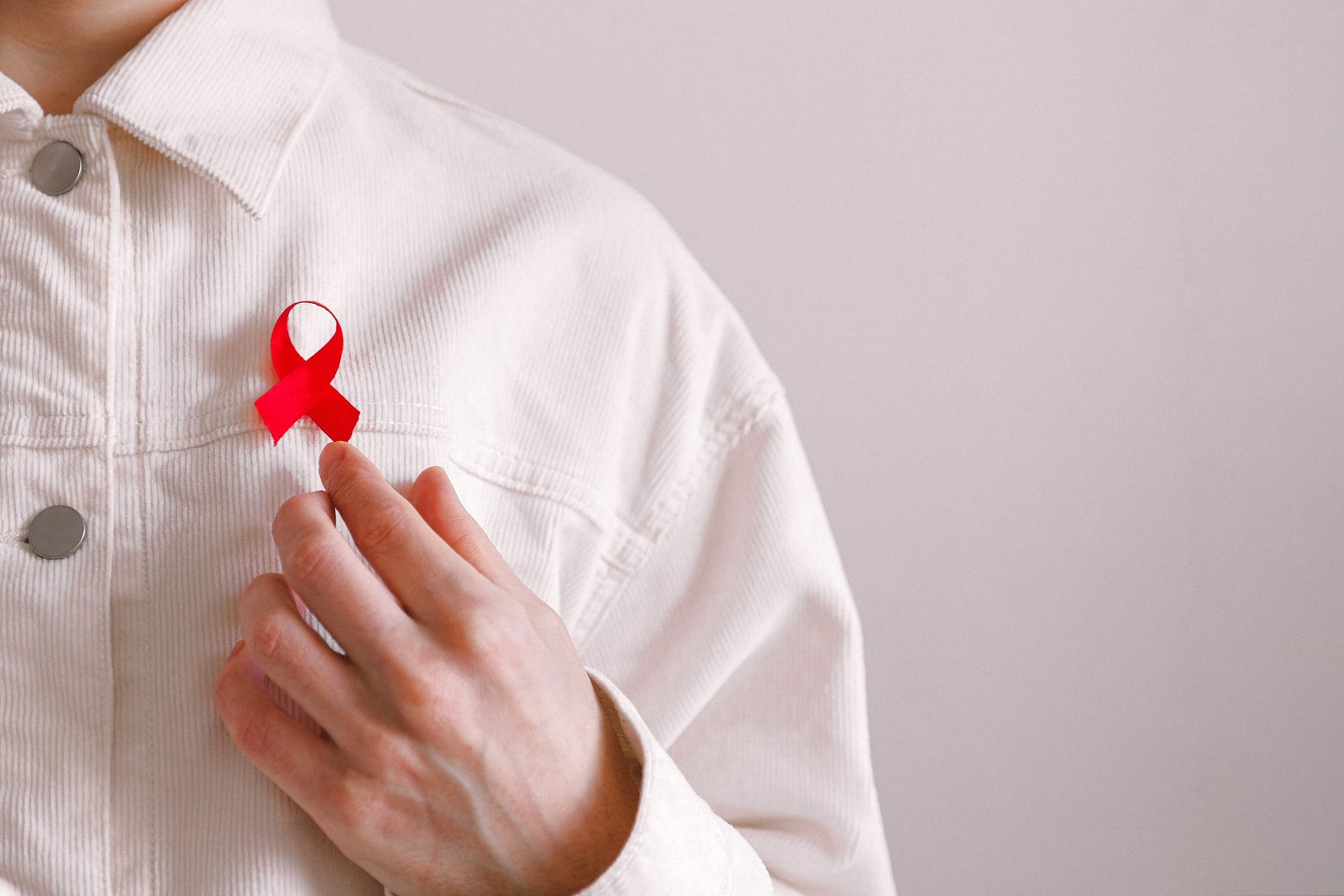 Férfi piros szalaggal az ingén az AIDS világnapján